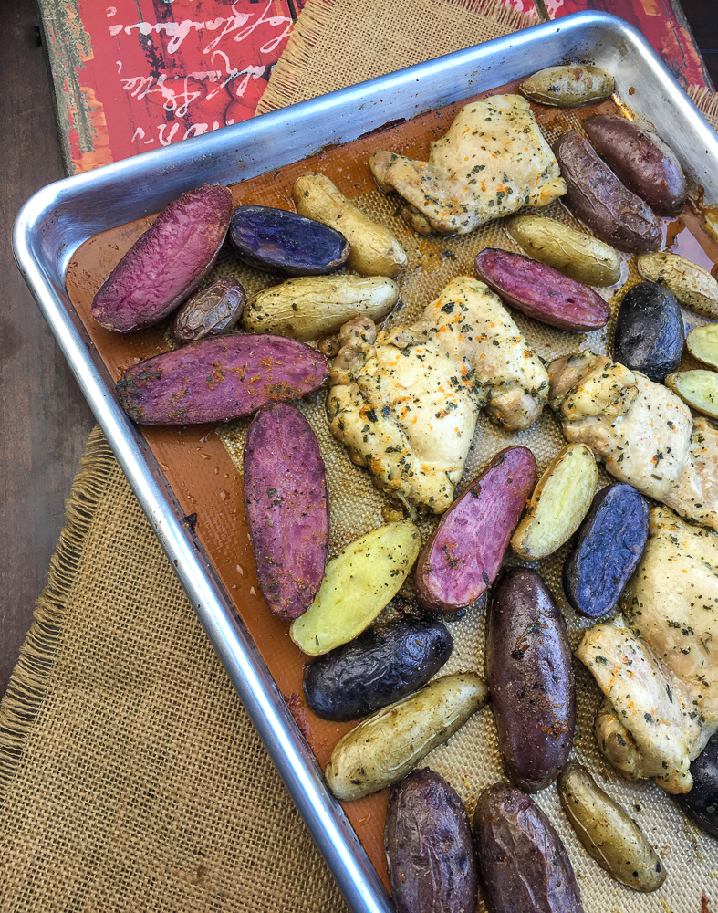 Marinated Baked Chicken Thighs with Fingerling Potatoes on a baking sheet