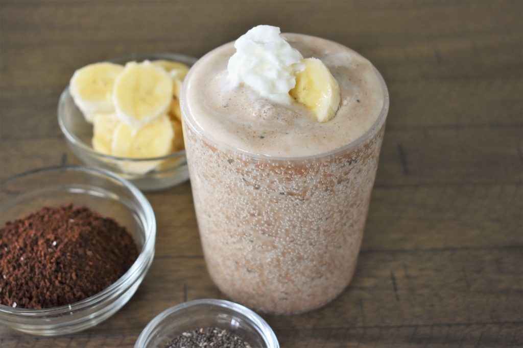 The Good Morning Coffee Banana Smoothie with a banana and whipped cream on top.
