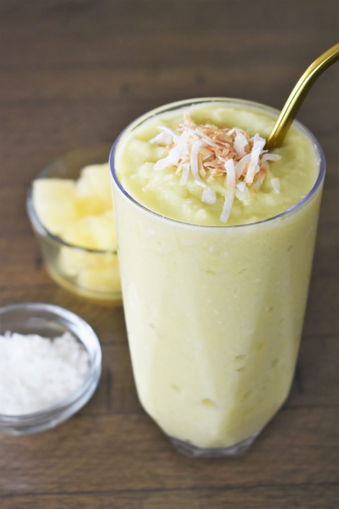 The Pineapple Avocado Smoothie with ingredients on the side.