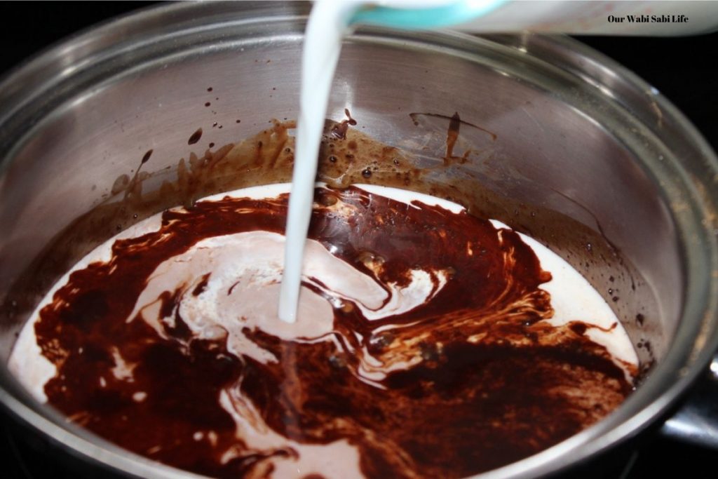 Adding the milk into the Boozy Hot Chocolate mixture.