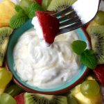 Dipping a strawberry into the yogurt dip.