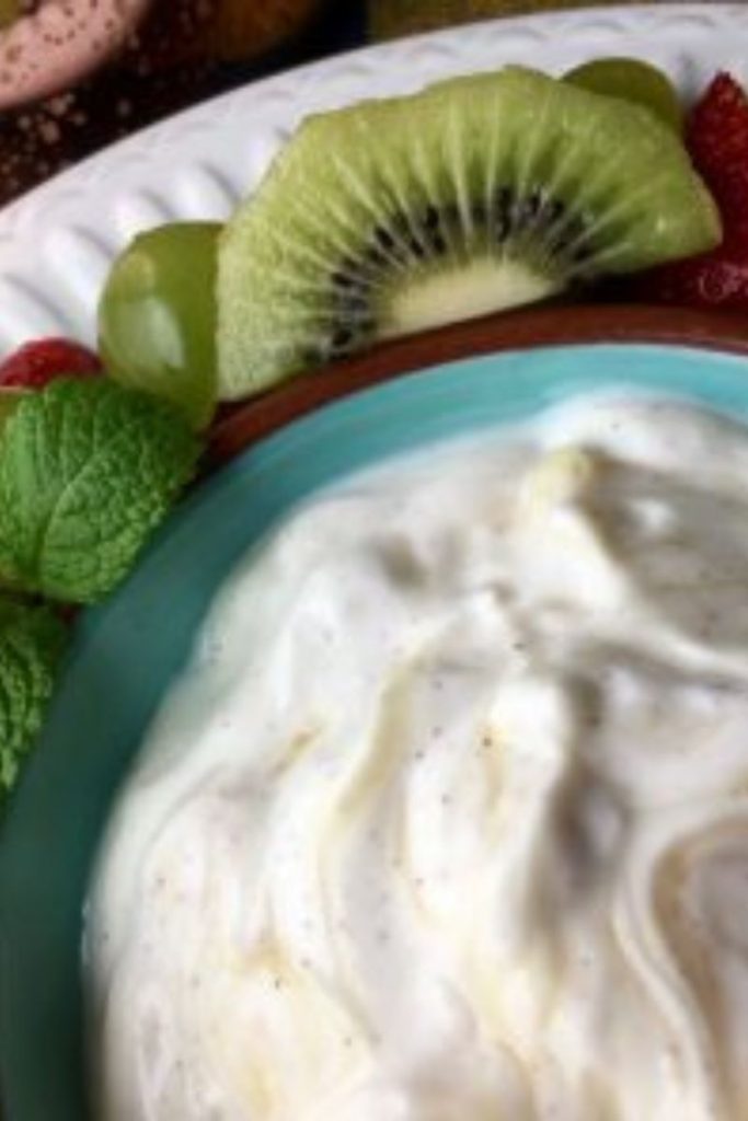 The yogurt dip from the grape salad recipe in a blue bowl.