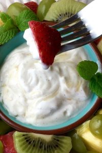 Dipping a strawberry into the yogurt dip.