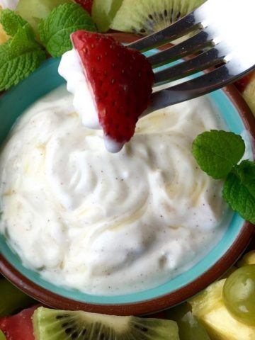 Dipping a strawberry into the yogurt dip.