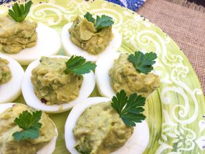 Avocado Deviled Eggs on green plate.