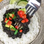 A fork lifting up some of the Cuban Style Black Beans.