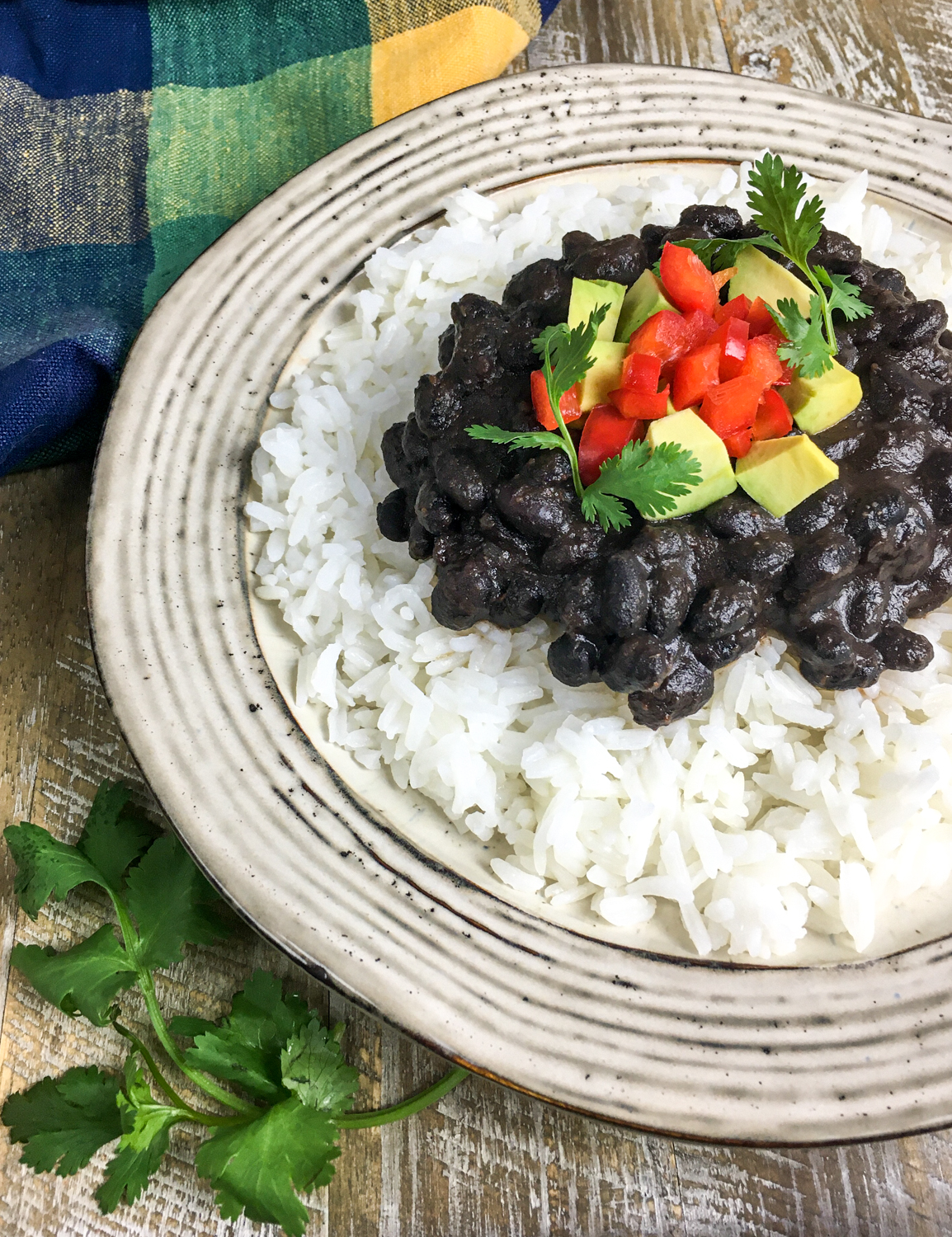 Cuban Style Black Beans topped with pepper, cilantro, and avocado.