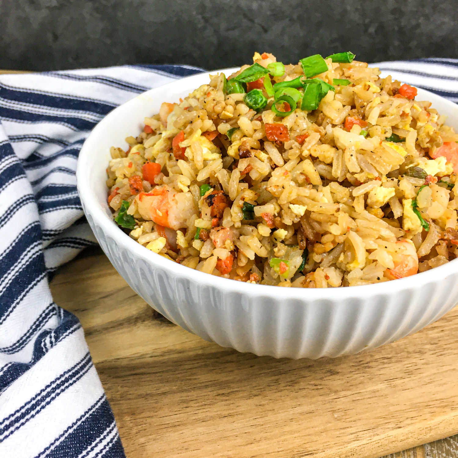 Easy Shrimp Fried Rice on a brown cutting board.